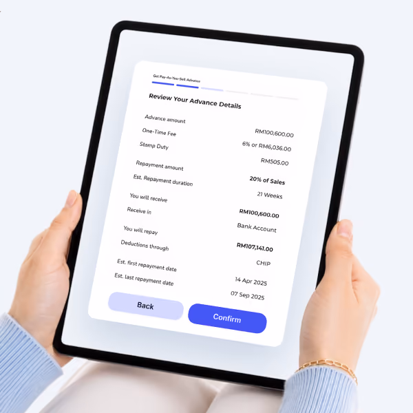 Hands holding tablet showing a loan advance review screen with details and confirm button.